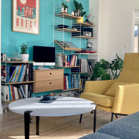 Composition mixte bibliothèque/hifi String, avec en premier plan la table basse Venezia de Tiptoe et le fauteuil Siri de Sits